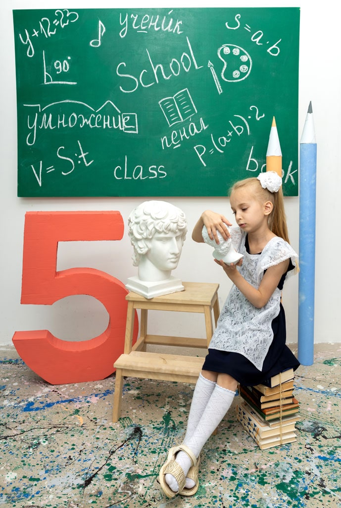 Девочка позирует на фоне школьной фотолокации
